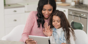 Mae ensinando filha com tablet