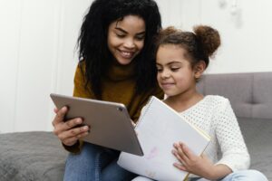 Mãe ensinando filha no tablet